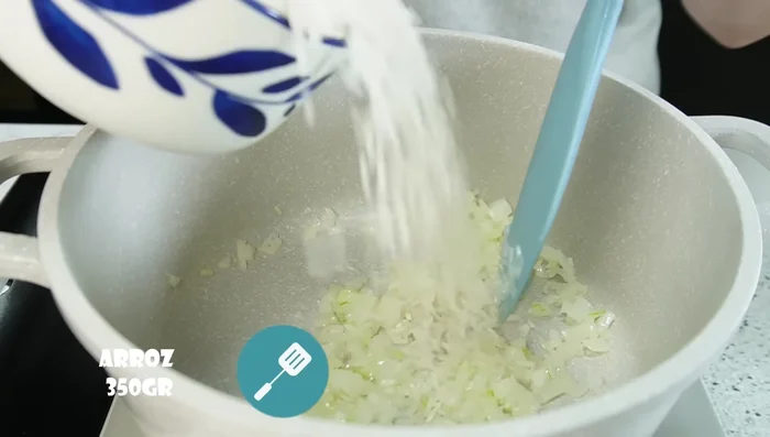 Agregar el arroz y mezclar, sofreír hasta que esté transparente (aproximadamente 2 minutos).