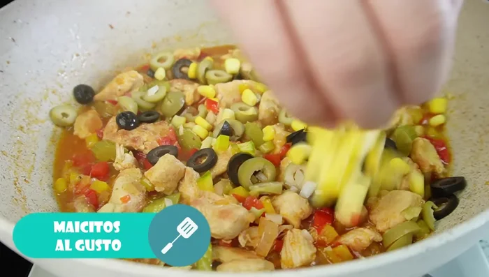 Agregar las aceitunas, maíz, cebolla de rama y cilantro o perejil. Mezclar.