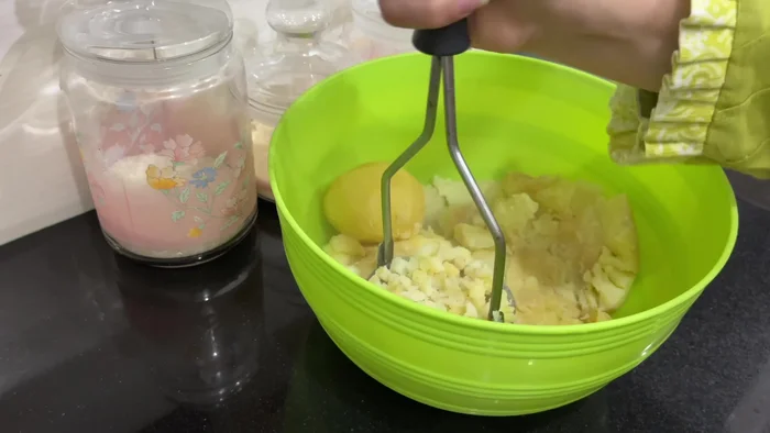 Machacar las patatas.