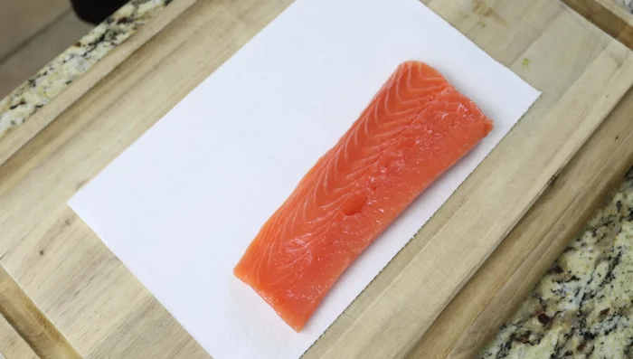 Secar los filetes de salmón con toallas de papel. Sazonarlos con sal y pimienta.