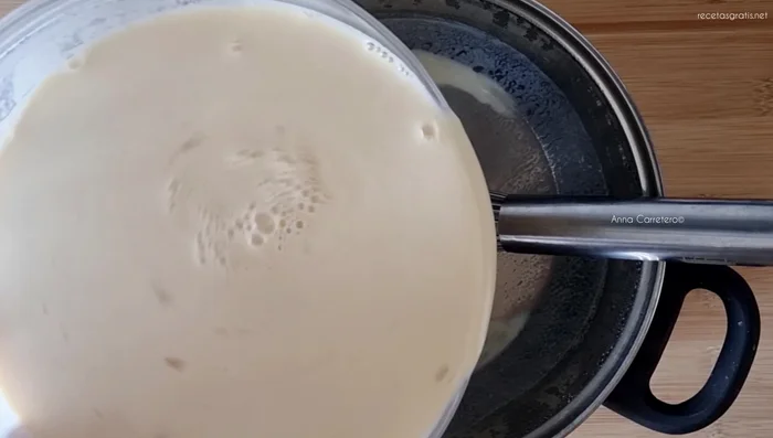 Colar la leche caliente y volverla a poner en la cazuela a fuego medio, removiendo constantemente hasta que espese.