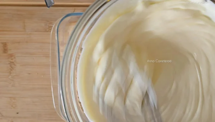 Agrega la mezcla de nata, leche condensada y limón sobre la capa de galletas.