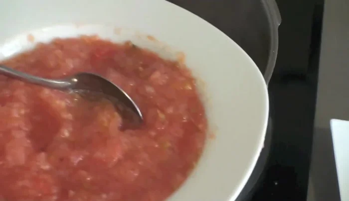 Incorporar el tomate rallado, seguir removiendo y añadir el vino tinto.