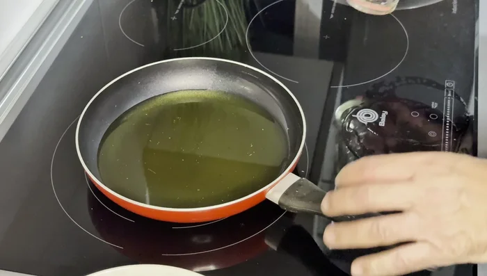 En una sartén mediana, calentar 300 ml de aceite de oliva. Freír las patatas a fuego medio bajo, removiendo ocasionalmente para que no se peguen. (70.56)