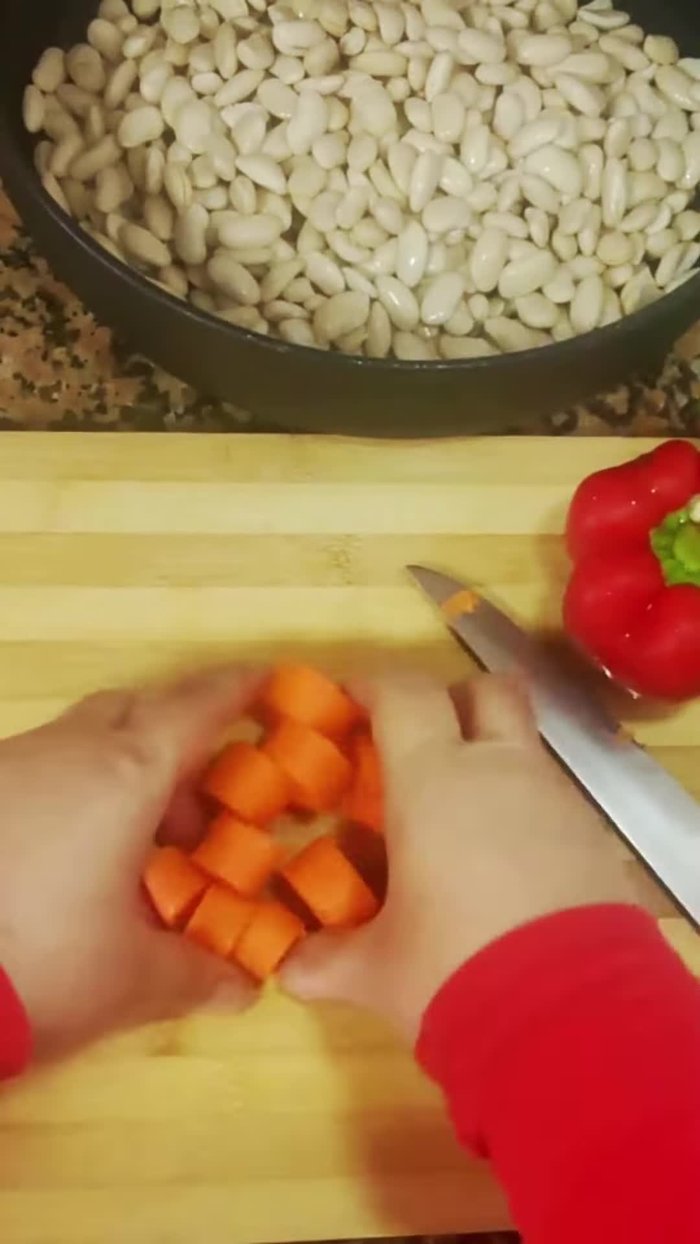Añadir una zanahoria cortada, pimiento rojo y verde en trozos, una cebolla, una cucharada de sal y cubrir con agua.