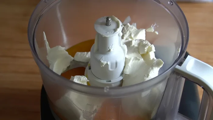 En el procesador de alimentos, batir las yemas con 500 g de queso crema, 200 g de yogur griego, orégano, una pizca de sal, 1 cucharada de harina y 1 cucharada de mostaza hasta obtener una mezcla homogénea.