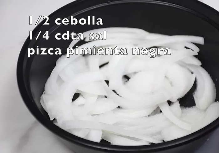 Mezclar la cebolla blanca con 1/4 cucharadita de sal, una pizca de pimienta negra molida y 2 cucharaditas de pan molido. Dejar reposar unos 5 minutos.
