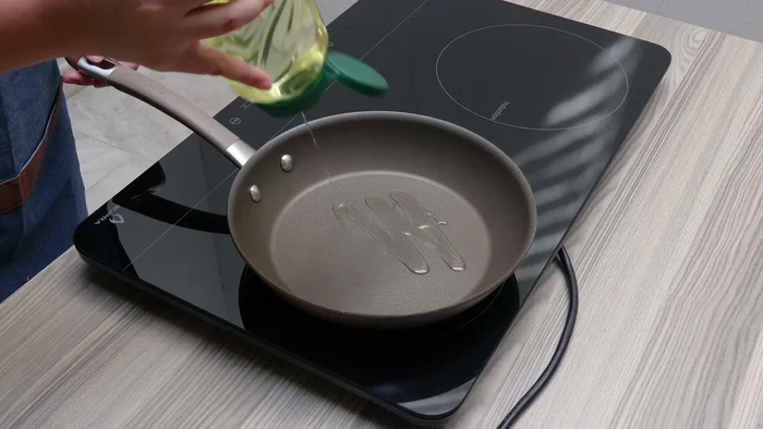 Retirar el pollo del fuego. En una sartén con aceite, vaciar las piezas de pollo y sazonar con pimienta negra molida, ajo en polvo y sal. Dorar por un rato.
