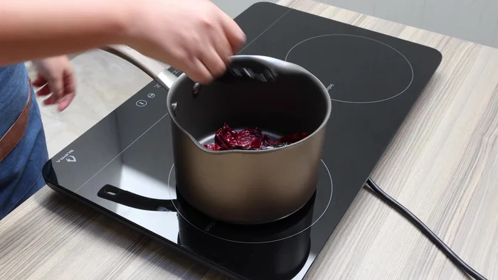 En otra olla, cocina 10 chiles guajillo sin venas ni semillas, 2 chiles pasilla, 1 chile ancho, 3 chiles de árbol y 1 jitomate limpio, con suficiente agua hasta cubrirlos. Tapa y cocina a fuego medio durante 10 minutos (115.52).