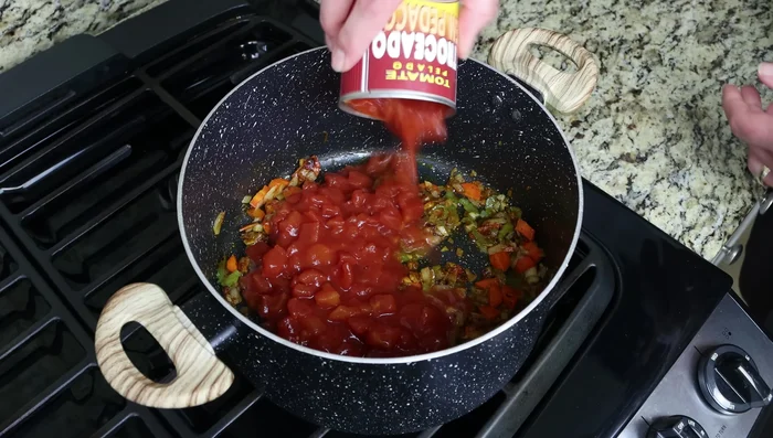 Agregar los tomates cortados en cubitos. Subir a fuego alto, mezclar y cocinar a fuego lento durante 5 minutos.
