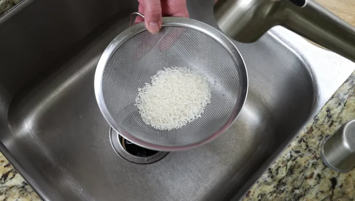 Agregar el arroz enjuagado. Mezclar suavemente y bajar el fuego a lento. Cocinar durante 20 minutos, o hasta que las lentejas y el arroz estén cocidos.