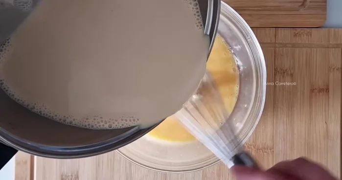 Vierte la mezcla en un molde con caramelo líquido y hornea en baño María a 160°C durante 55 minutos.