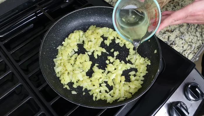 Incorporar el vino blanco seco, el tomillo y mezclar bien. Cocinar a fuego lento durante 3 minutos.