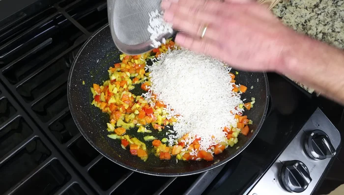 Agrega el arroz enjuagado y los garbanzos. Sazona con sal y pimienta.