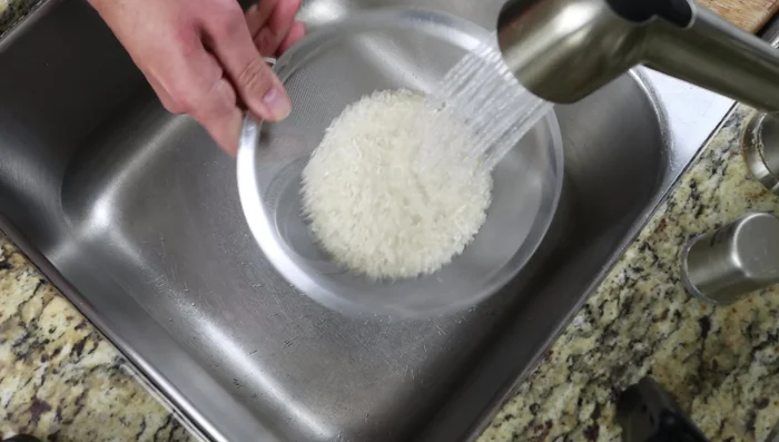 Enjuaga el arroz bajo el agua hasta que el agua salga transparente (aprox. 1 minuto).
