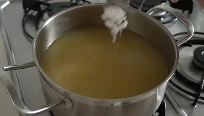 Llevar el caldo a ebullición y rectificar de sal, pimienta negra y nuez moscada.