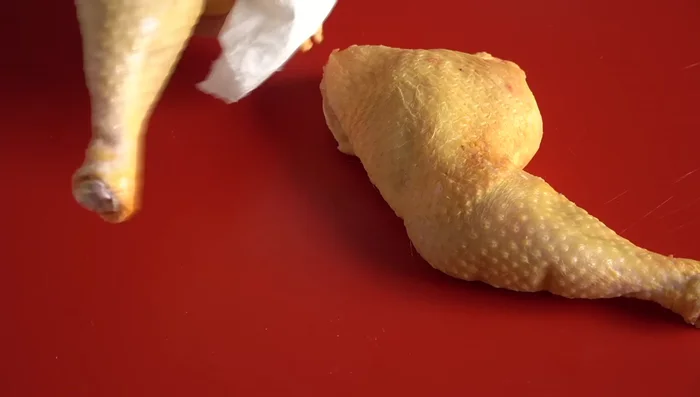 Retirar la piel de los cuartos traseros de pollo para reducir la grasa del caldo. Partirlos en dos.