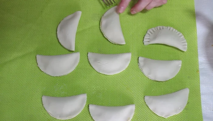 Colocar las empanadillas en una bandeja de horno y pintarlas por encima con huevo batido.