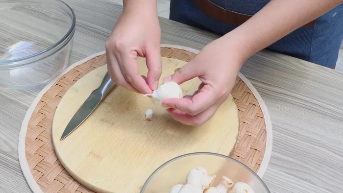 Mientras el brócoli se cocina, limpiar los champiñones quitando la primera capa y cortarlos a lo largo en tamaños medianos.