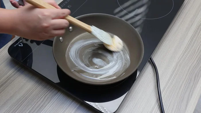 En una sartén, calentar un chorrito de aceite y una cucharada de mantequilla. Agregar 1/4 de cebolla finamente picada y un diente de ajo sofreír a fuego medio.