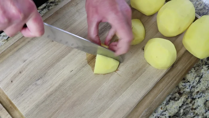 Pelar, lavar y secar las papas. Cortarlas en trozos del tamaño de un bocado (2 cm o 3/4 de pulgada).