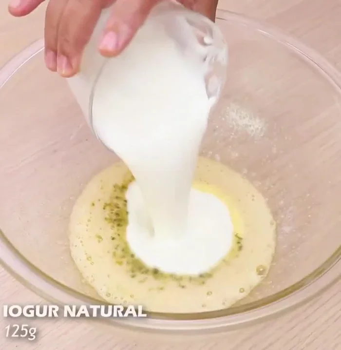 Añadir 125 g de yogur natural, la cáscara de naranja y mezclar bien.