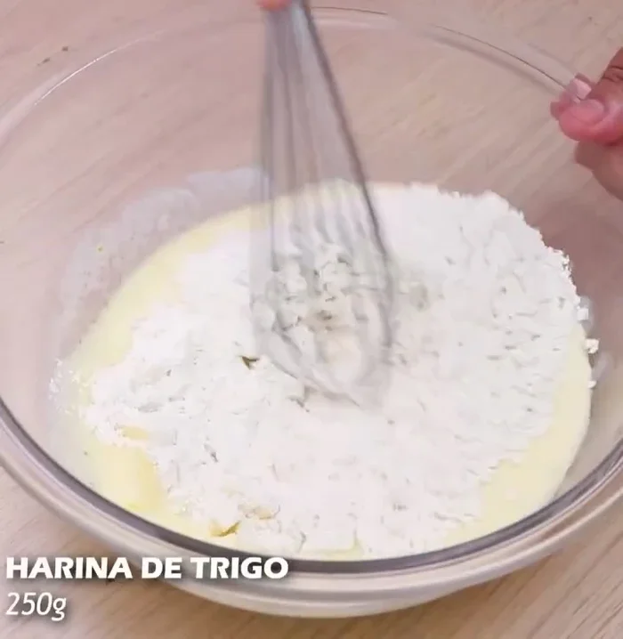 Agregar 250 g de harina de trigo y mezclar bien con una espátula.