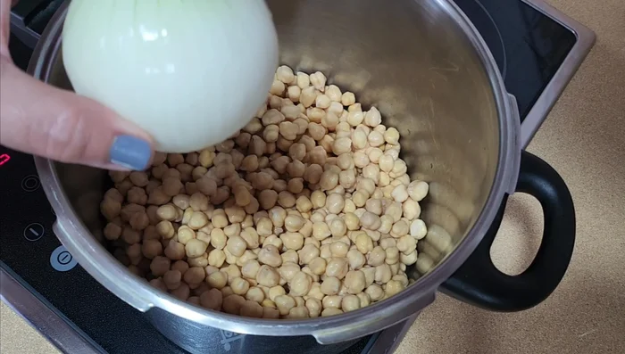 Remojar los garbanzos desde la noche anterior. Añadir cebolla, ajo, laurel, y sal a los garbanzos remojados. Cubrir con agua y llevar a ebullición. Retirar la espuma blanca. Cocer a fuego lento durante 30 minutos.