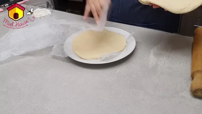Estirar la porción más pequeña de masa para la tapa. Humedecer los bordes de la base con agua. (368.599 - 434.4)