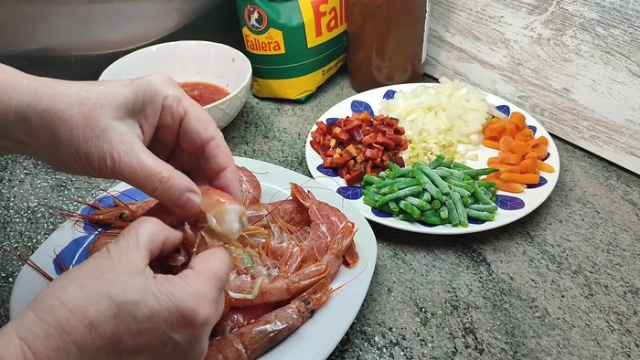 Pelar los langostinos y retirar la vena. Conservar las cabezas para el caldo.