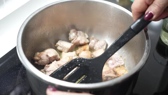 Cuando las costillas comiencen a cambiar de color, añade el resto de ingredientes: pimiento, cebolla y ajo.
