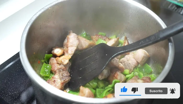 Sofríe el pimiento durante 3-4 minutos, luego agrega la cebolla y el ajo.