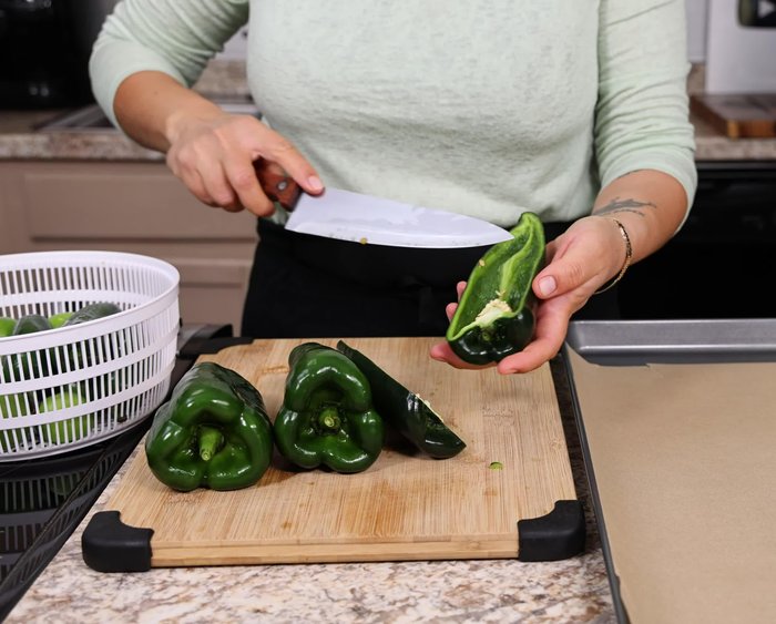 Cortar los chiles poblanos por la mitad, quitarles el rabito y las semillas. Limpiar bien.