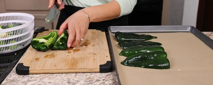 Colocar los chiles poblanos, jalapeños (con o sin semillas) y tomatillos en una charola con papel para horno o papel encerado. Rociar con aceite en aerosol. Hornear a 350°F (180°C) por 15-20 minutos (o asar en sartén/comal).