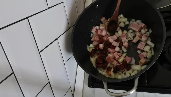 Agregar el chorizo y el bacon cortados. Dejar que suelten su grasa.