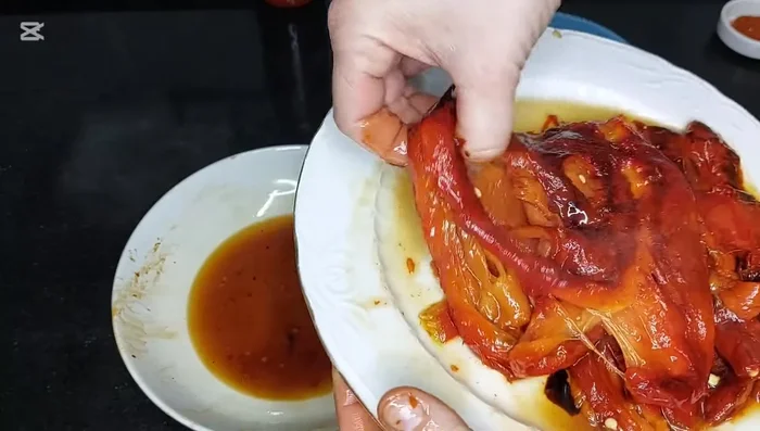 Pelar y cortar los pimientos asados en tiras. Reservar el jugo. (176.04)