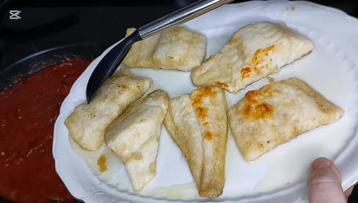 En una bandeja de horno, colocar una capa del sofrito de tomate y pimientos. (277)