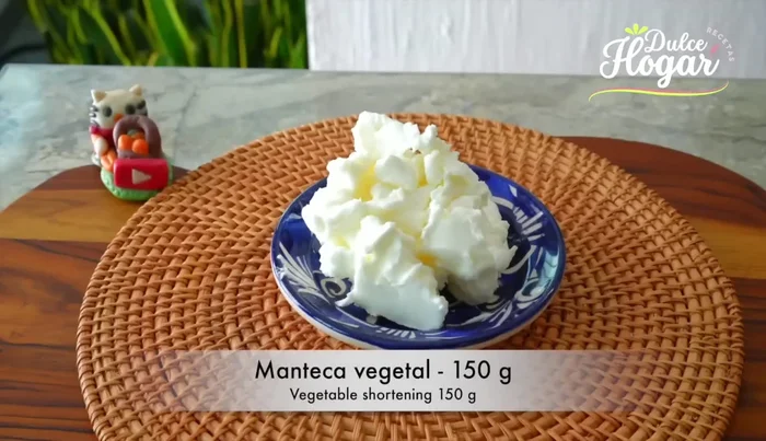 Preparar la masa: Batir la manteca vegetal y la mantequilla hasta obtener una consistencia cremosa. Añadir el azúcar y la sal, continuar batiendo.