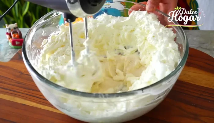 Incorporar la mantequilla, la fécula de maíz, la media crema, la leche condensada, los huevos y la esencia de vainilla. Batir hasta integrar.