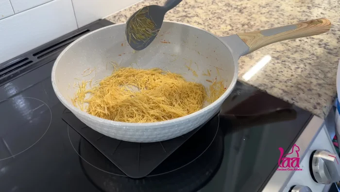 Añadir el licuado de tomate a la sartén con el fideo. Agregar caldo de gallina o más agua si es necesario.
