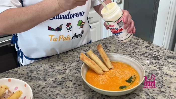Servir el caldo de fideo caliente con los taquitos dorados de papa y queso, crema y queso fresco (opcional).