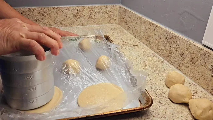 Usando un recipiente plano y limpio, aplastar ligeramente cada bolita para darle forma.