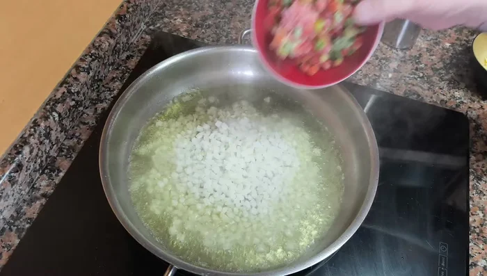 Agregar la cebolla, el pimiento y el ajo picados. Sofreír hasta que estén ligeramente dorados.