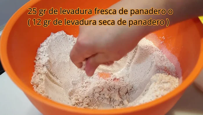 Hacer un hueco en el centro de la harina y añadir el azúcar, la levadura y el agua tibia poco a poco (la harina integral absorbe más agua).
