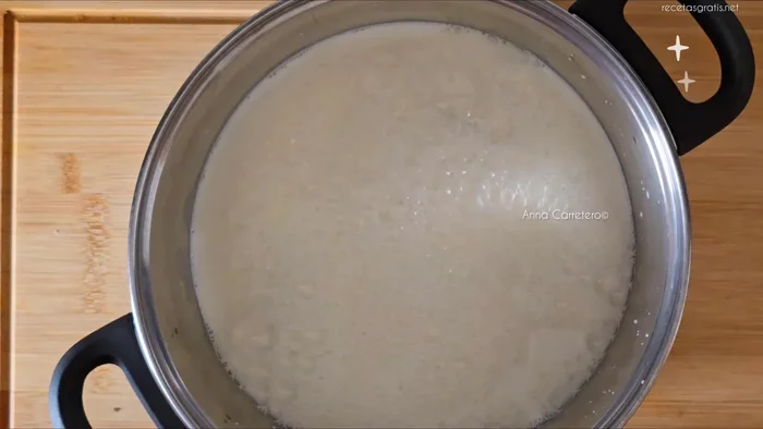 Calentar la leche con el palito de canela, la piel de naranja y el chocolate blanco a fuego medio durante 7 minutos.