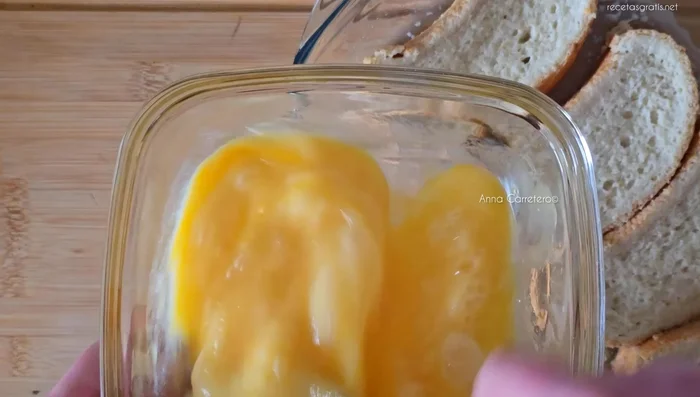 Pasar el pan empapado en leche por los huevos batidos.
