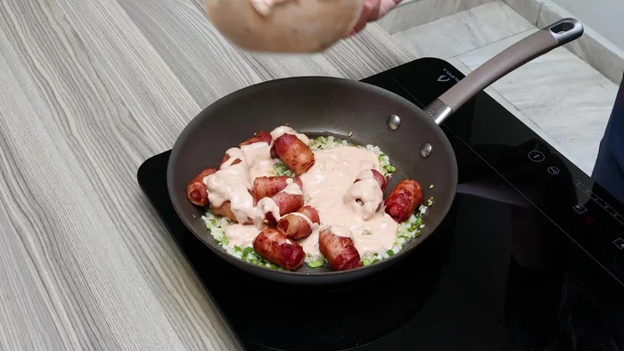 Añadir la salsa de media crema y chipotle a las salchichas.