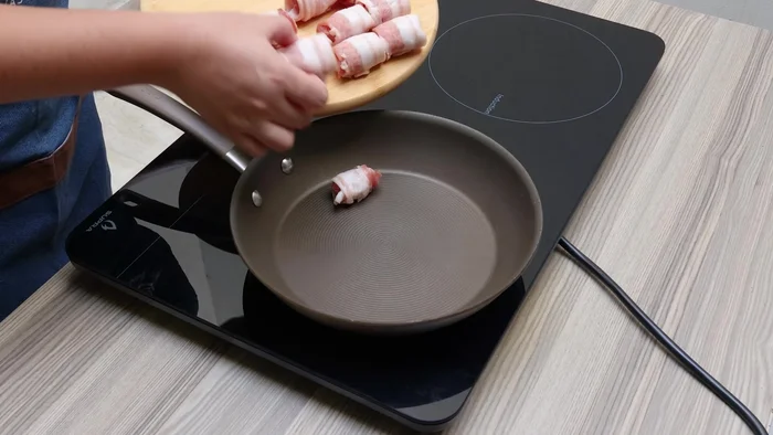 Dorar las salchichas en una sartén a fuego medio sin aceite (el tocino soltará su grasa). Darles vuelta ocasionalmente.