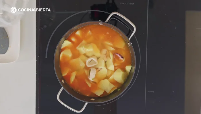 Añade agua hasta cubrir todo y una pastilla de caldo de pescado o gallina. Deja cocinar a fuego medio durante 40 minutos, removiendo ocasionalmente para que los sabores se integren.