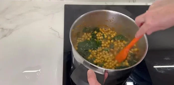 Agregar al sofrito el caldo con los garbanzos y verduras cocidas, el puré de verduras trituradas y el azafrán.